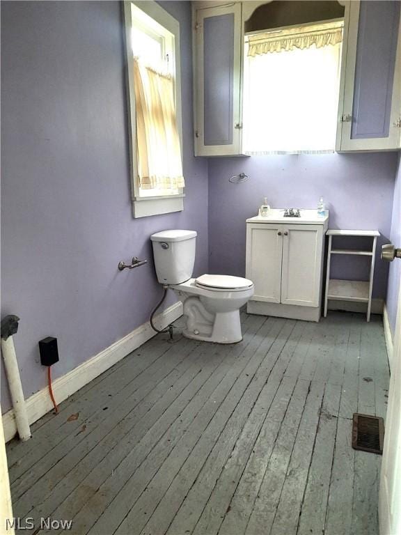 bathroom featuring hardwood / wood-style flooring, a healthy amount of sunlight, and toilet