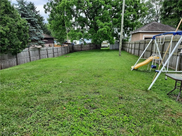 view of yard with a playground and a storage unit