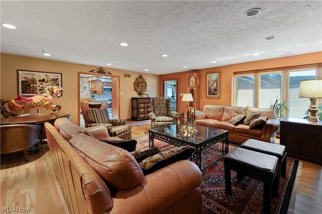 living room featuring a textured ceiling and light hardwood / wood-style floors