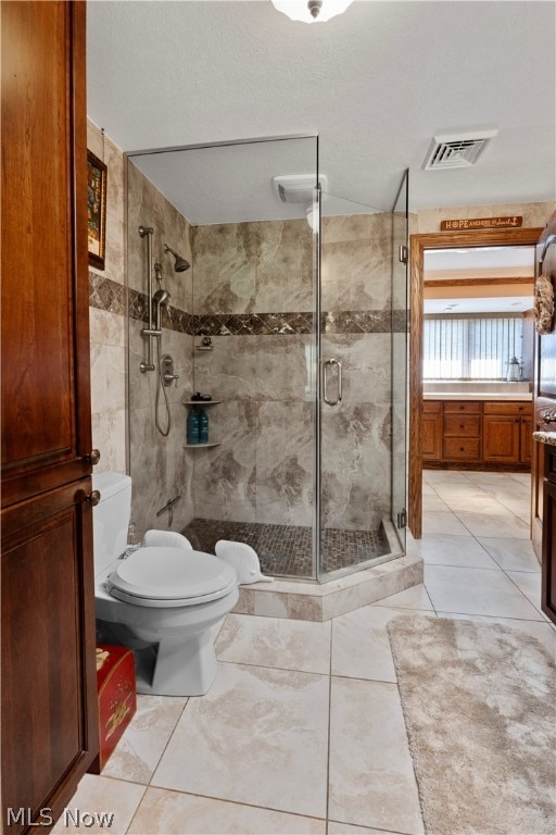 bathroom with toilet, vanity, tile patterned floors, and a shower with shower door