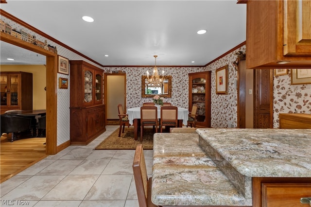 dining space with light tile patterned floors, an inviting chandelier, and crown molding