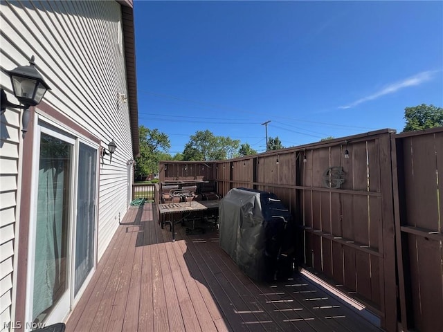 wooden terrace featuring a grill