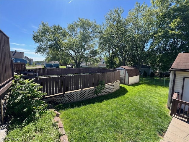 view of yard with a storage shed, an outdoor structure, and fence