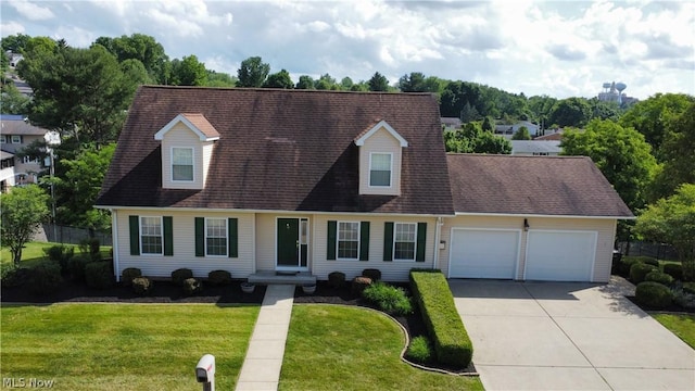 new england style home featuring a garage and a front lawn