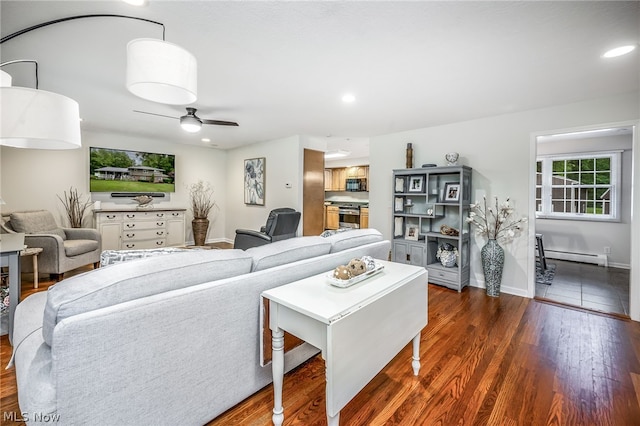 living room with a baseboard radiator, ceiling fan, and dark wood-type flooring