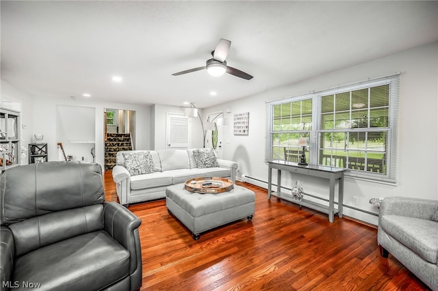 living room featuring hardwood / wood-style flooring, ceiling fan, and a baseboard heating unit