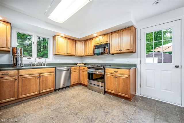 kitchen featuring plenty of natural light, light tile patterned flooring, sink, and appliances with stainless steel finishes