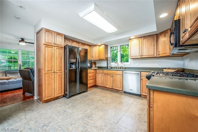 kitchen featuring light tile patterned floors, sink, ceiling fan, and black appliances