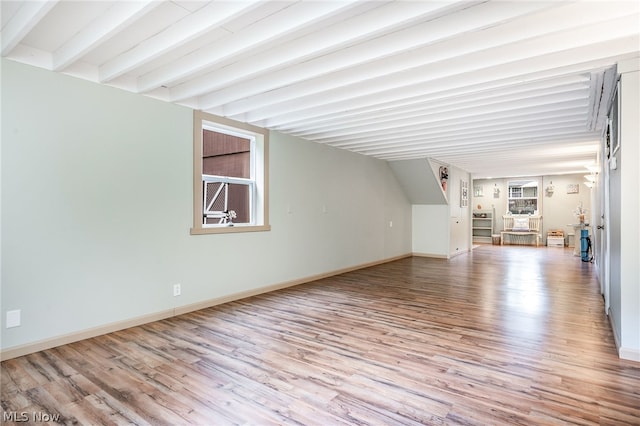 unfurnished living room with beamed ceiling and light hardwood / wood-style flooring