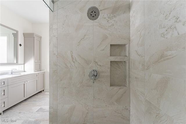 bathroom featuring a tile shower and vanity