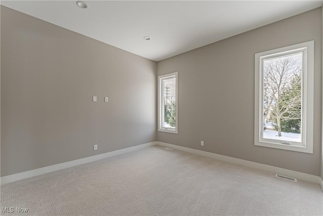 unfurnished room featuring light carpet