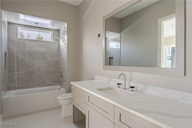 full bathroom with tile patterned floors, tiled shower / bath combo, toilet, and vanity