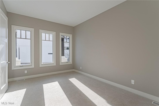 unfurnished room featuring light colored carpet