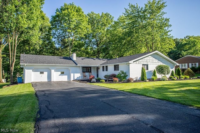 ranch-style house with a garage and a front lawn