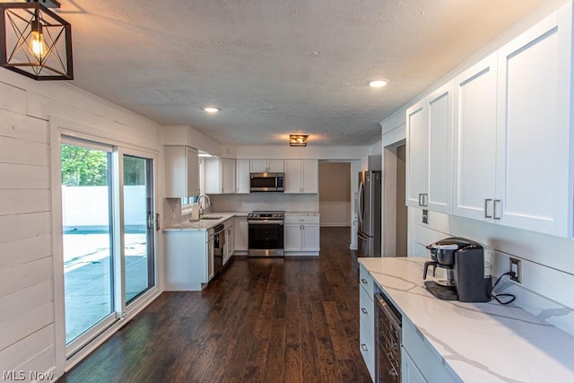 kitchen featuring white cabinets, sink, stainless steel appliances, and dark wood-type flooring