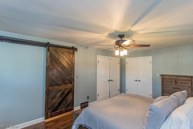 bedroom featuring carpet flooring, a barn door, and ceiling fan