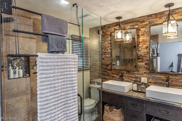 bathroom featuring vanity, a shower with door, toilet, and tile walls