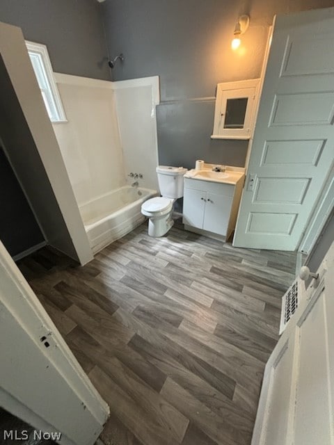 full bathroom featuring shower / bath combination, wood-type flooring, toilet, and vanity