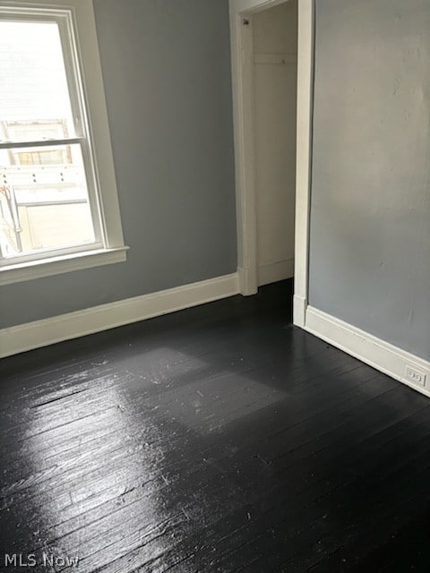 unfurnished room with dark hardwood / wood-style floors and plenty of natural light