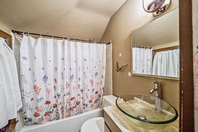 full bathroom with vaulted ceiling, shower / tub combo with curtain, toilet, and vanity with extensive cabinet space