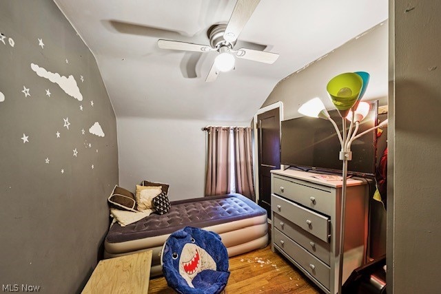 bedroom featuring ceiling fan, hardwood / wood-style flooring, and lofted ceiling