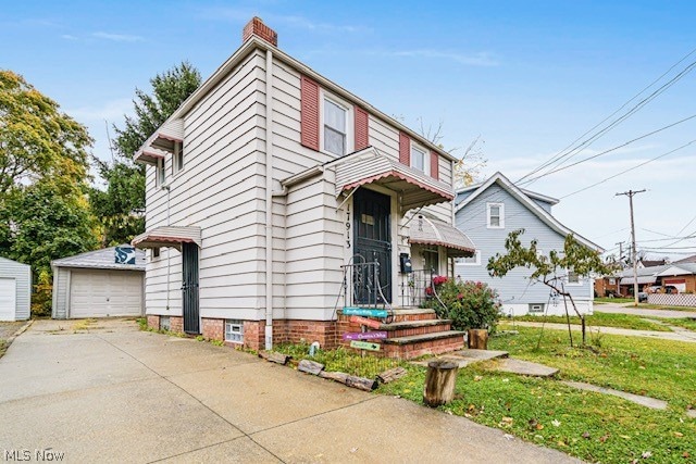 view of front of property with an outdoor structure, a garage, and a front lawn