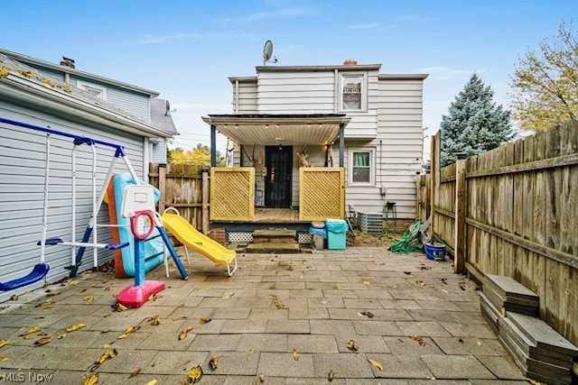 back of property featuring a playground, a patio area, and central air condition unit