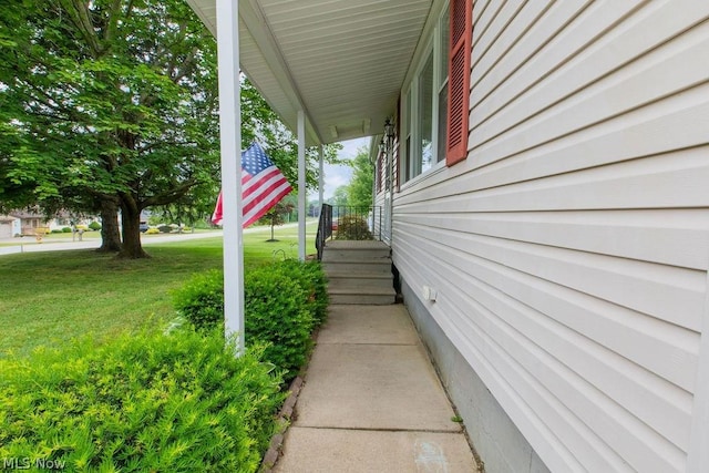 view of home's exterior featuring a porch and a yard