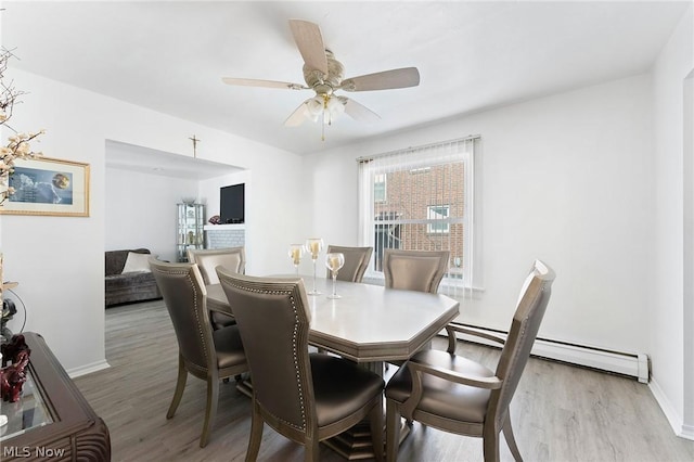 dining area with ceiling fan, hardwood / wood-style floors, and a baseboard heating unit