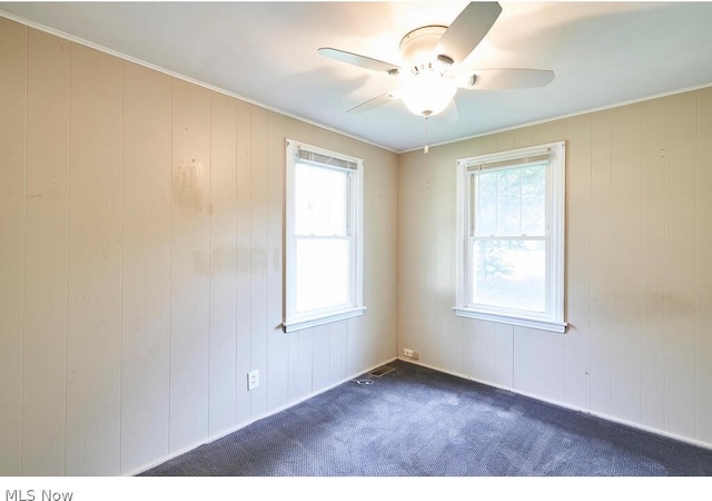 carpeted spare room featuring ceiling fan