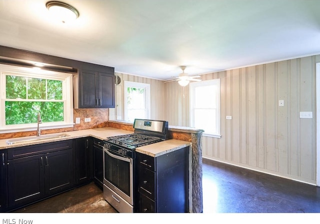 kitchen featuring stainless steel gas range, sink, and a healthy amount of sunlight