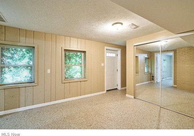 unfurnished bedroom with multiple windows, a closet, and a textured ceiling