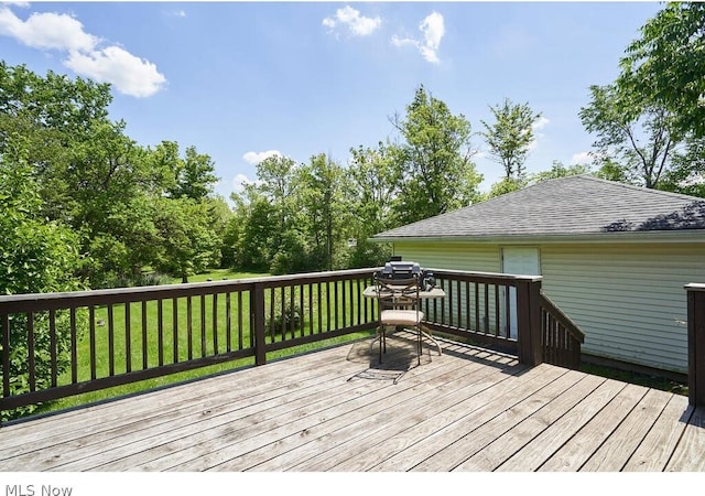 wooden terrace featuring a lawn