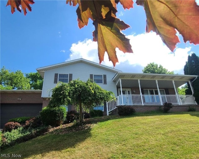 view of front of property with a garage, a porch, a front yard, and brick siding