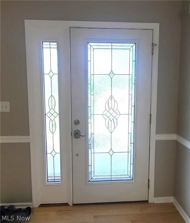 entryway featuring a wealth of natural light, baseboards, and light wood finished floors