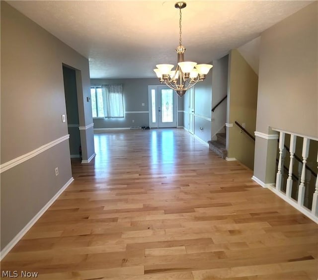 interior space featuring a chandelier, light wood-type flooring, and stairway