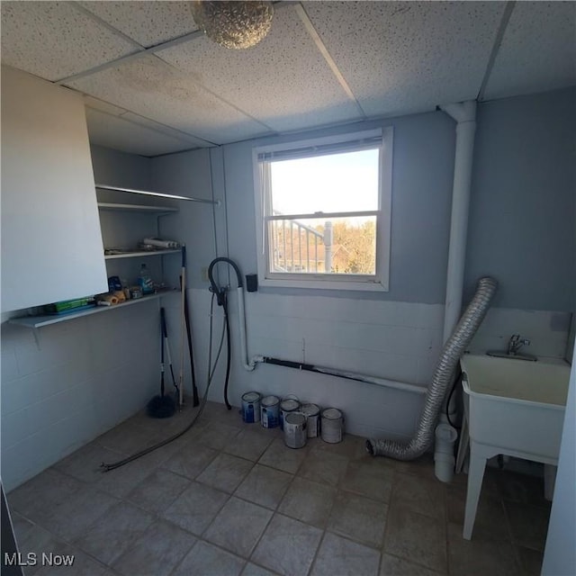 laundry room with concrete block wall and laundry area