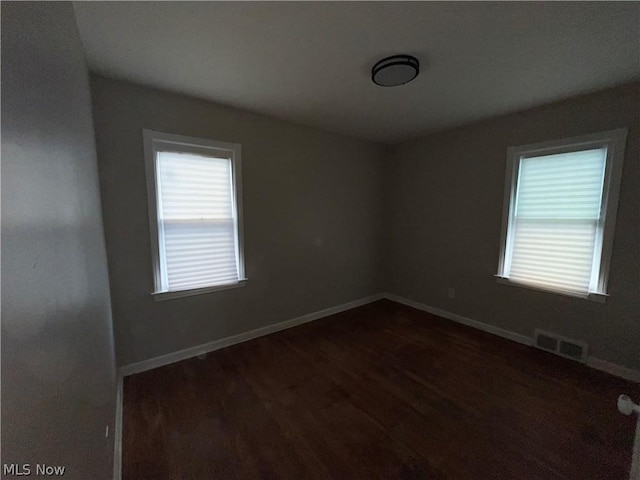 empty room with dark hardwood / wood-style floors