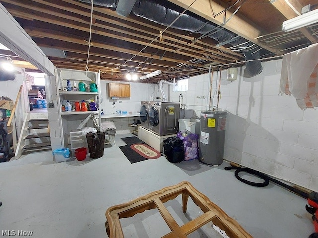 basement featuring electric water heater and washing machine and dryer