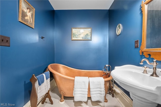 bathroom with sink and a tub to relax in