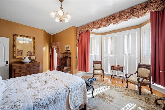 bedroom with hardwood / wood-style floors and a chandelier