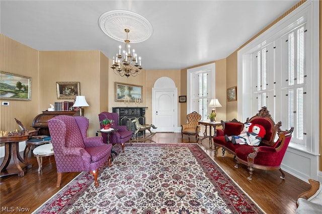 living room featuring a healthy amount of sunlight, a chandelier, and dark hardwood / wood-style flooring