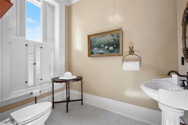 bathroom with sink, toilet, and a healthy amount of sunlight