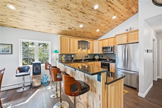 kitchen with lofted ceiling, dark stone countertops, decorative backsplash, stainless steel appliances, and light brown cabinetry