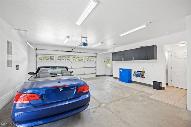 garage with a garage door opener and electric panel