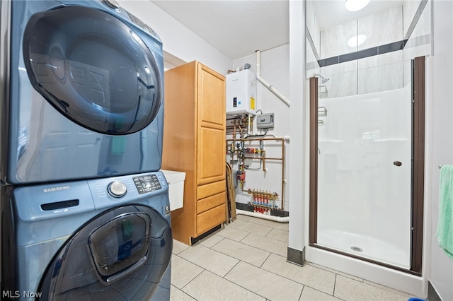 laundry area featuring water heater, cabinets, stacked washer and dryer, and light tile patterned flooring