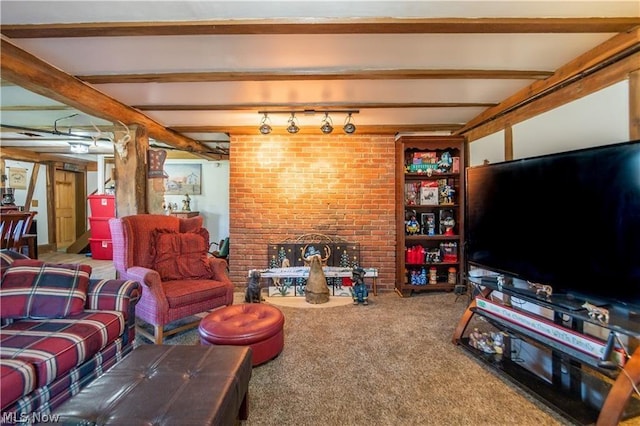 living room featuring beam ceiling, a brick fireplace, rail lighting, and carpet