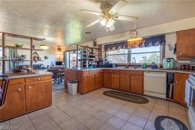 kitchen with sink, kitchen peninsula, white dishwasher, a textured ceiling, and light tile patterned floors