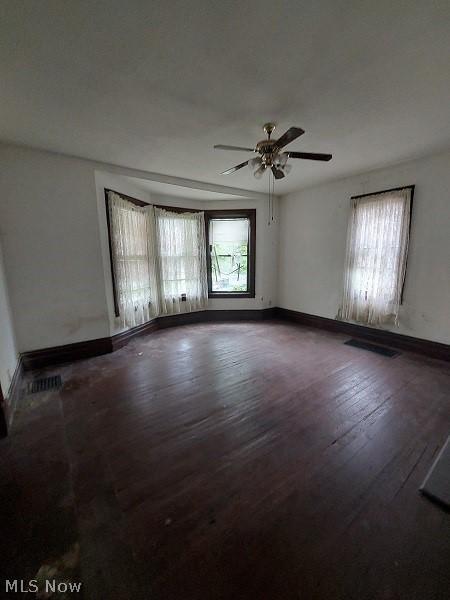 empty room with hardwood / wood-style flooring and ceiling fan