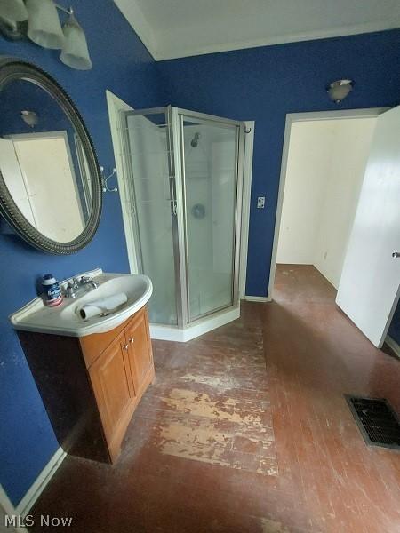 bathroom with vanity, a shower with door, and hardwood / wood-style floors